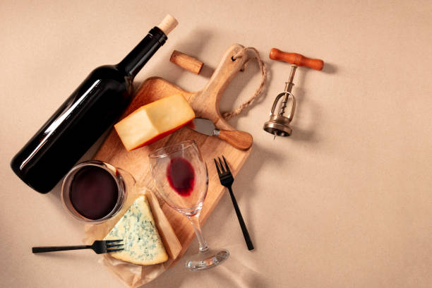 wine and cheese tasting, top shot on a brown background, with a cork, corkscrew, and a bottle, with a place for text - restaurant wine table table for two imagens e fotografias de stock