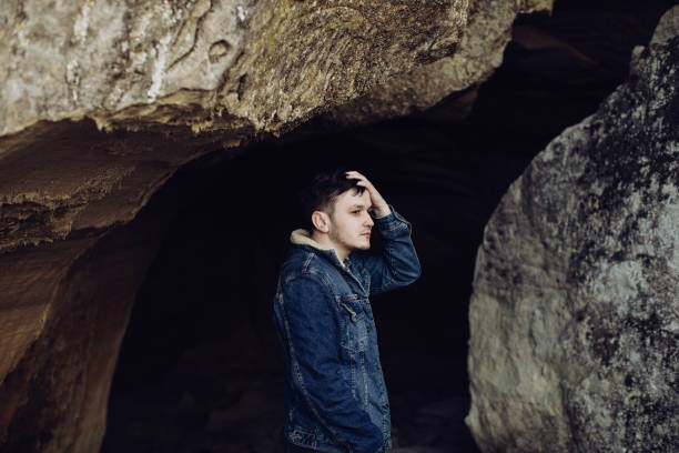 istock Young man in the mountains in a cave 1218945762