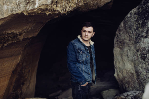 istock Young man in the mountains in a cave 1218945788
