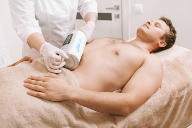 male client receiving hardware body massage at cosmetology clinic - abdomen abdominal muscle muscular build beautiful imagens e fotografias de stock