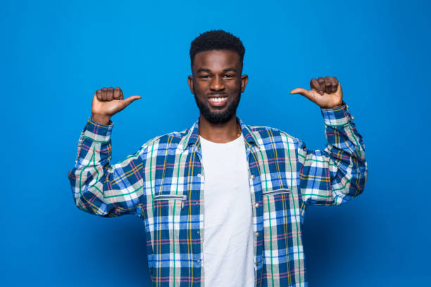 istock African handsome man pointing back isolated on blue background 1218948536