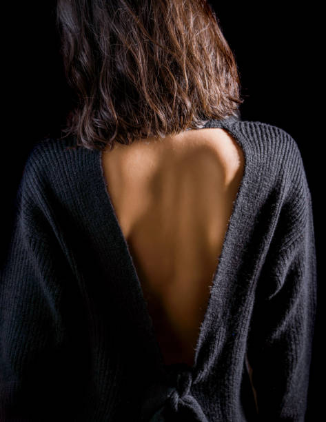Close-up detail photo of young woman wearing open back blouse stock photo
