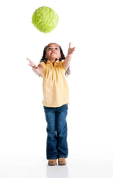 istock Little Girl Tossing a Ball on White Background 121895004