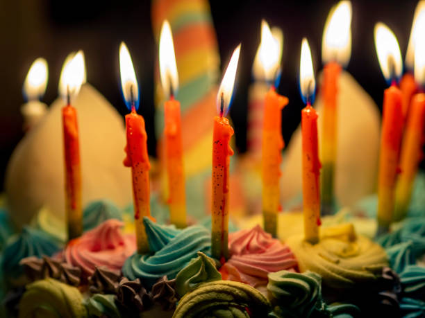 istock Lit up candles burning on a birthday cake 1218950184