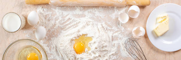 istock Kitchen table with ingredients for cooking baking. Copy space. Cooking concept. Eggs, flour on background. Dough ingredients. Banner. 1218950276