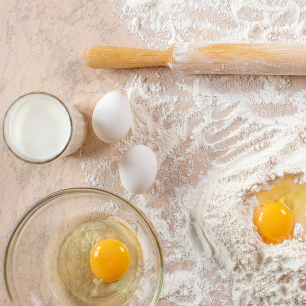istock Kitchen table with ingredients for cooking baking. Copy space. Cooking concept. Eggs, flour on background. Dough ingredients. Square. 1218950324