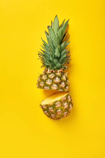 istock Healthy Eating. Halved pineapple isolated on yellow 1218950531