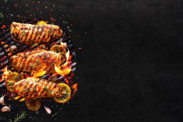 grilled chicken breasts on a grill plate on black background with copy space, - grilled chicken chicken barbecue fire imagens e fotografias de stock