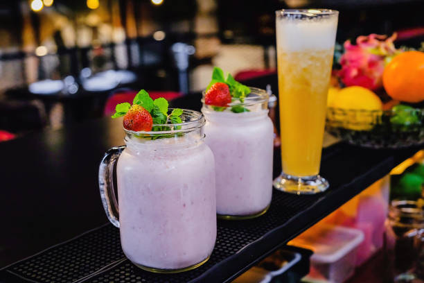 Close up shot of fresh strawberry juice and orange juice above bar, healthy drink to boost your immune system during Coronavirus outbreak