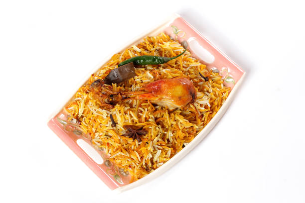 Delicious spicy chicken biryani in traditional bowl on White background, Indian or Pakistani famous masala rice food. Potato and meat are main ingredients of this recipe | Best Ramadan iftar meal.