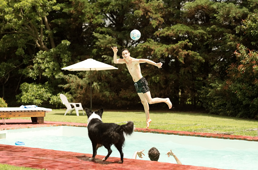 Shot of two young male friends playing with a soccer ball in swimming pool