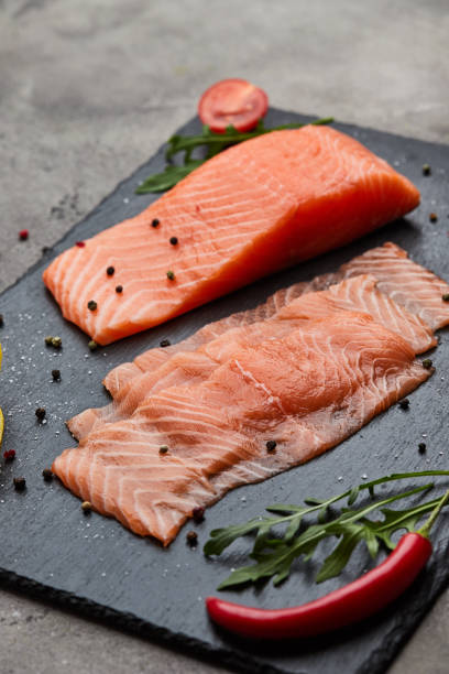 istock Fresh sliced salmon fillet with arugula, avocado and lemon on slate plate. Wild atlantic fish 1218960233