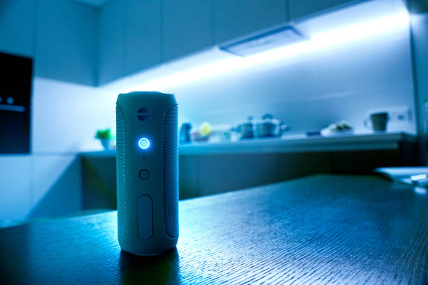 Evening concept. Modern chinese assistant speaker column standing in home interior on kitchen background. Multifunctional device easy use. Bluetooth voice smart robot. Horizontal banner Copy space say