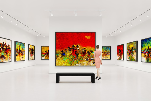 Young woman visits art exhibition and looking at the fine art paintings in a art gallery.
