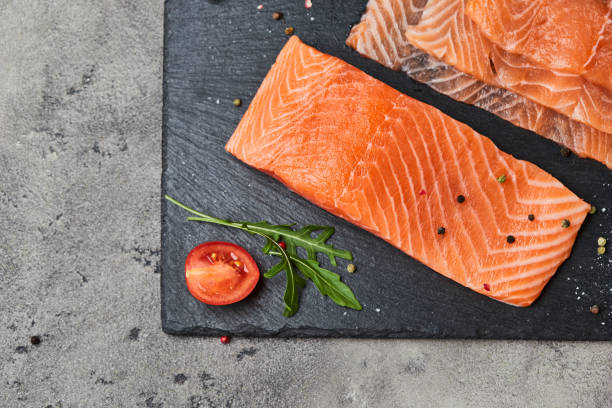 istock Fresh sliced salmon fillet with arugula, avocado and lemon on slate plate. Wild atlantic fish 1218961166