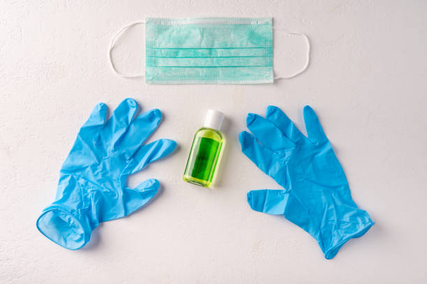 istock Hand sanitizer gel bottle, face mask, rubber gloves on light background. Copy space 1218963949