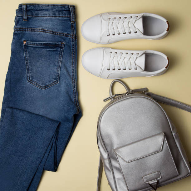 istock Blue jeans, white sneakers, silver backpack. Top view. New look 1218965177