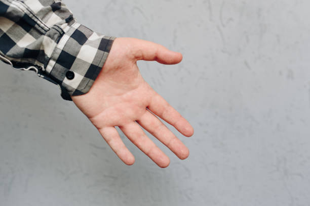 istock a man's hand in a shirt on a light blue background 1218965790
