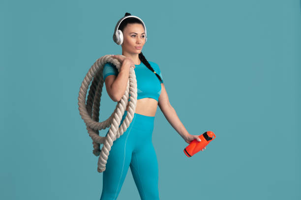 istock Beautiful young female athlete practicing on blue studio background, monochrome portrait 1218966750