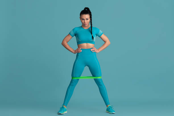 istock Beautiful young female athlete practicing on blue studio background, monochrome portrait 1218966833