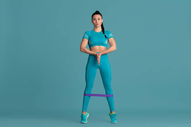 istock Beautiful young female athlete practicing on blue studio background, monochrome portrait 1218966836