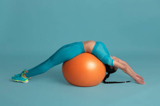 istock Beautiful young female athlete practicing on blue studio background, monochrome portrait 1218966860