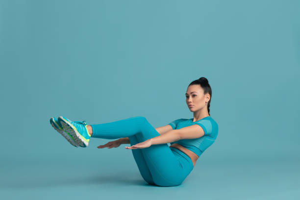 istock Beautiful young female athlete practicing on blue studio background, monochrome portrait 1218966910