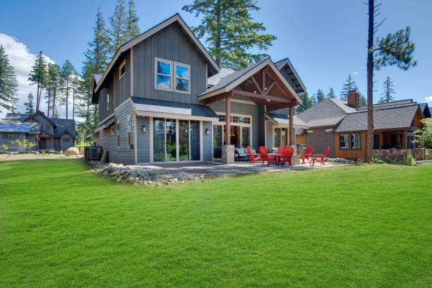 Great modern and rustic American home interiors and exteriors. Huge open to nature Back yard with fire pit , amazing patio and red chairs near newly bild luxury real estate home with forest biew and green grass. northwest stock pictures, royalty-free photos & images