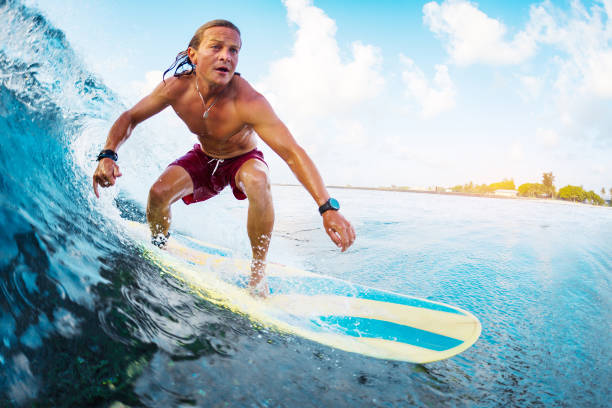 istock Young surfer rides the ocean wave in Maldives 1218968711