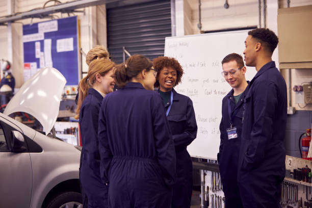 istock Students Studying For Auto Mechanic Apprenticeship At College Standing By Whiteboard 1218969276