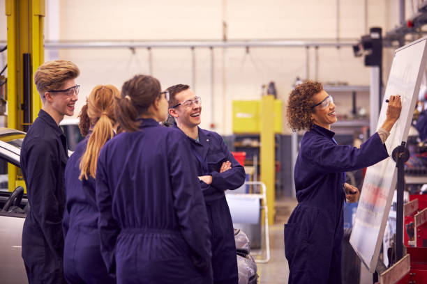 istock Female Tutor By Whiteboard With Students Teaching Auto Mechanic Apprenticeship At College 1218969912
