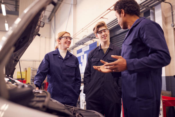 istock Male Tutor With Students Looking At Car Engine On Auto Mechanic Apprenticeship Course At College 1218970000