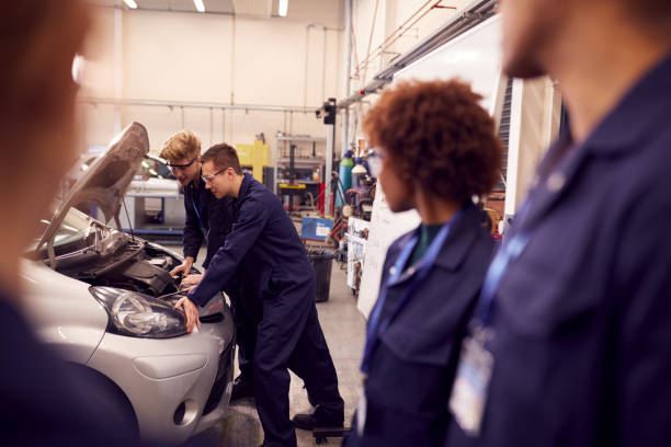 istock Students Studying For Auto Mechanic Apprenticeship At College Working On Car Engine 1218970179