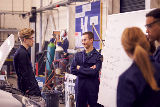 istock Students Studying For Auto Mechanic Apprenticeship At College Standing By Whiteboard 1218970198