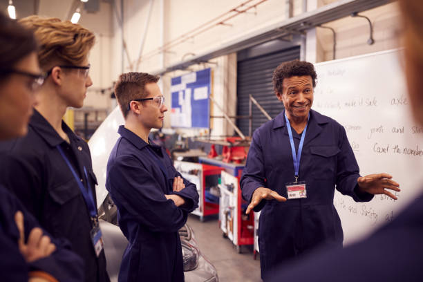 istock Male Tutor By Whiteboard With Students Teaching Auto Mechanic Apprenticeship At College 1218970243