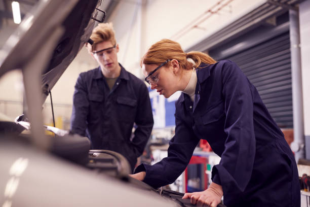 istock Male And Female Students Looking At Car Engine On Auto Mechanic Apprenticeship Course At College 1218970435