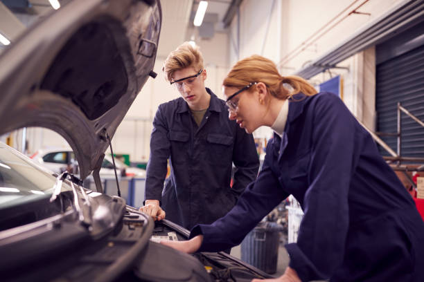 istock Male And Female Students Looking At Car Engine On Auto Mechanic Apprenticeship Course At College 1218971811