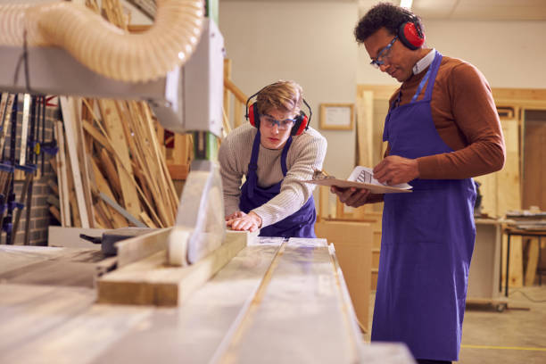 istock Tutor With Male Carpentry Student In Workshop Studying For Apprenticeship At College Using Bench Saw 1218971961