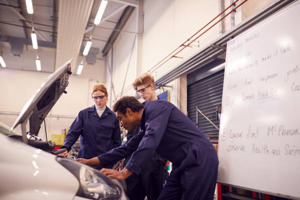 istock Male Tutor With Students Looking At Car Engine On Auto Mechanic Apprenticeship Course At College 1218972139