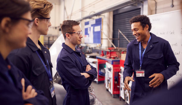 istock Male Tutor By Whiteboard With Students Teaching Auto Mechanic Apprenticeship At College 1218972301