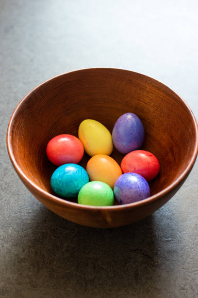 istock Colorful painted Easter Eggs in a brown wooden bowl shot in window daylight 1218973664