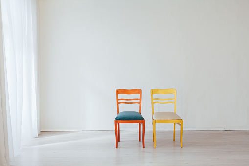two chairs in the interior of an empty white room