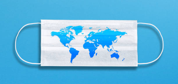 istock White face mask with a world map on blue background 1218974415