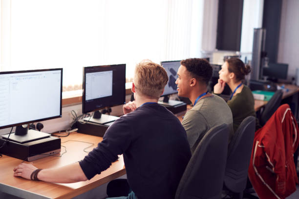 istock Group Of College Students Studying Computer Design Sitting At Line Of Monitors In Classroom 1218975091