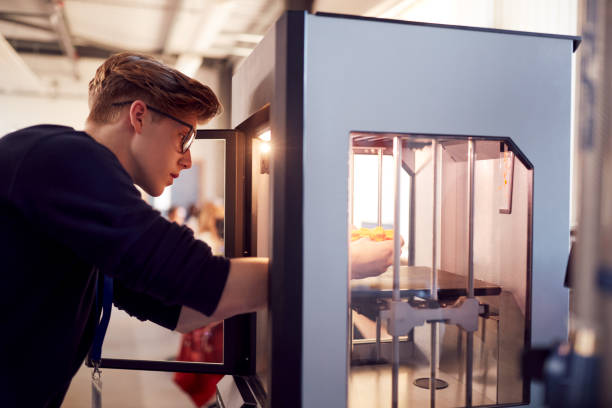 Male College Student Studying Engineering Using 3D Printing Machine Male College Student Studying Engineering Using 3D Printing Machine 3d printing photos stock pictures, royalty-free photos & images