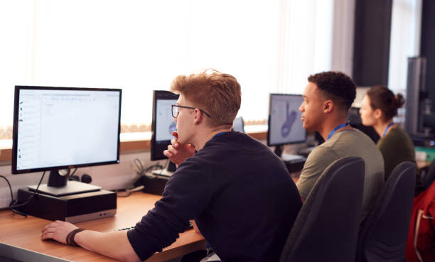 istock Group Of College Students Studying Computer Design Sitting At Line Of Monitors In Classroom 1218975561