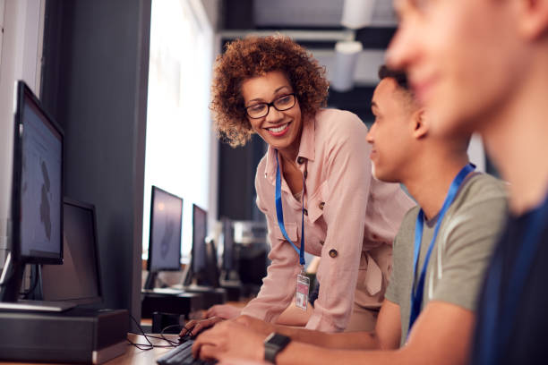istock Group Of College Students With Tutor Studying Computer Design Sitting At Monitors In Classroom 1218975640