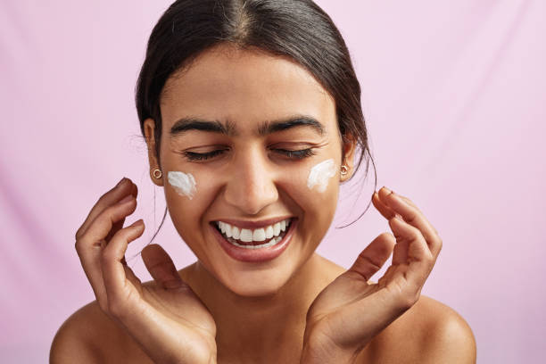 Moisturizing is what keeps your skin happy Studio shot of a beautiful young woman applying moisturizer to her face moisturizer photos stock pictures, royalty-free photos & images