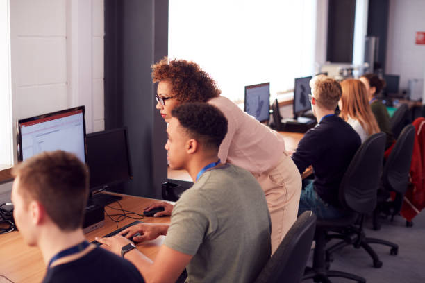 istock Group Of College Students With Tutor Studying Computer Design Sitting At Monitors In Classroom 1218975934