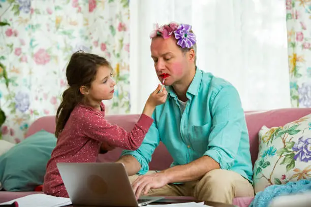 Photo of Child playing and disturbing father working remotely from home.
